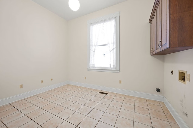 clothes washing area featuring cabinets, hookup for a washing machine, light tile patterned floors, and hookup for an electric dryer