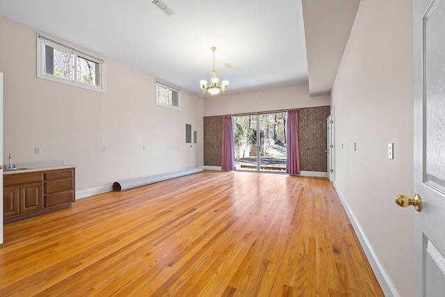 empty room featuring a notable chandelier, light hardwood / wood-style floors, and sink