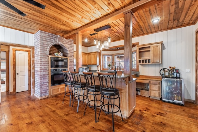 kitchen with light brown cabinets, wooden ceiling, dark wood-type flooring, wooden walls, and wine cooler