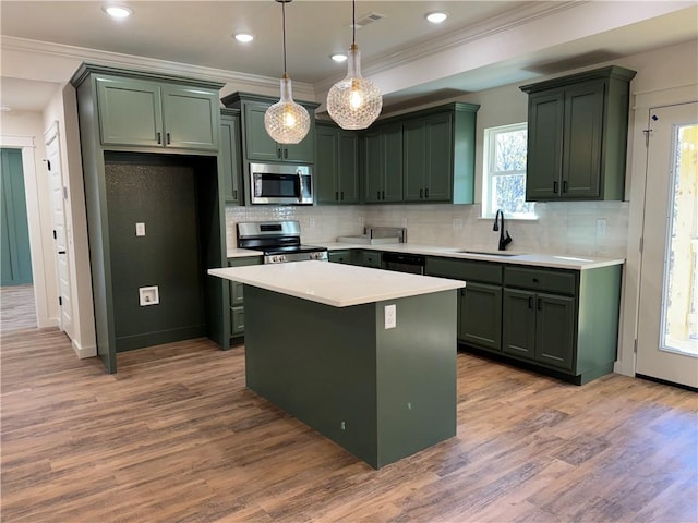 kitchen with a sink, light countertops, appliances with stainless steel finishes, and green cabinetry