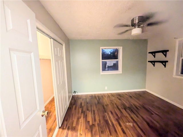 empty room featuring ceiling fan and dark hardwood / wood-style floors