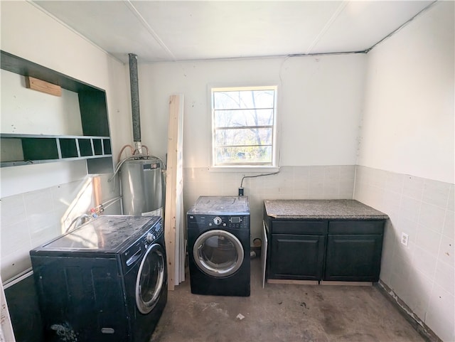 laundry area with washing machine and dryer and tile walls