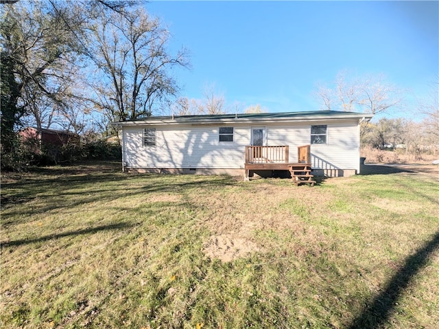 rear view of house with a wooden deck and a yard