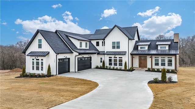 modern inspired farmhouse with a garage and a front lawn