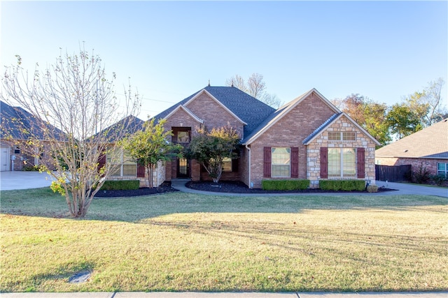 view of front of home with stone siding, brick siding, and a front yard