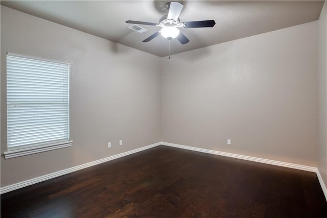 spare room with ceiling fan, baseboards, and dark wood finished floors