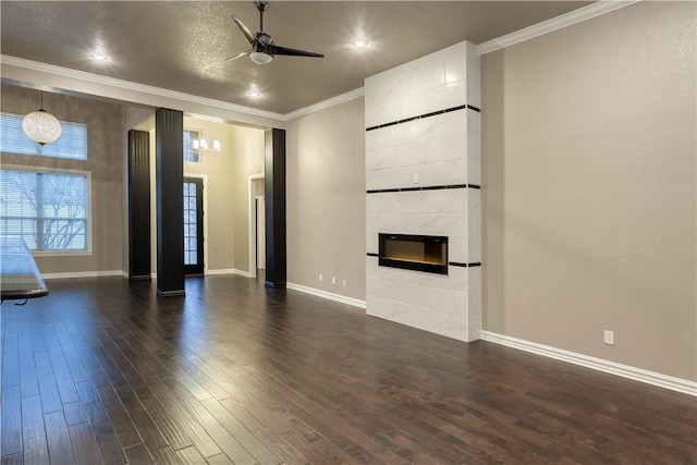 unfurnished living room with dark wood-style floors, a premium fireplace, baseboards, and crown molding