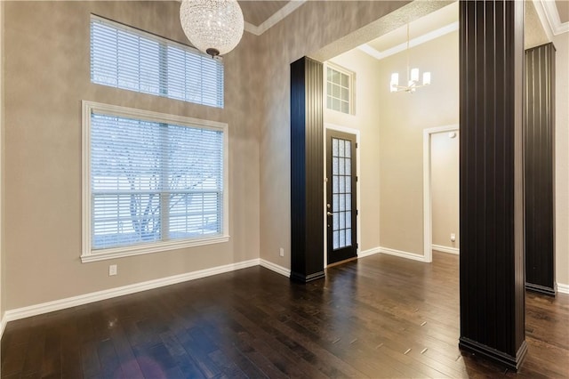 foyer entrance with a chandelier, crown molding, baseboards, and dark wood-style floors