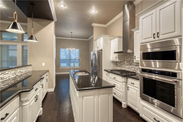 kitchen featuring wall chimney range hood, dark wood-style flooring, stainless steel appliances, and a sink