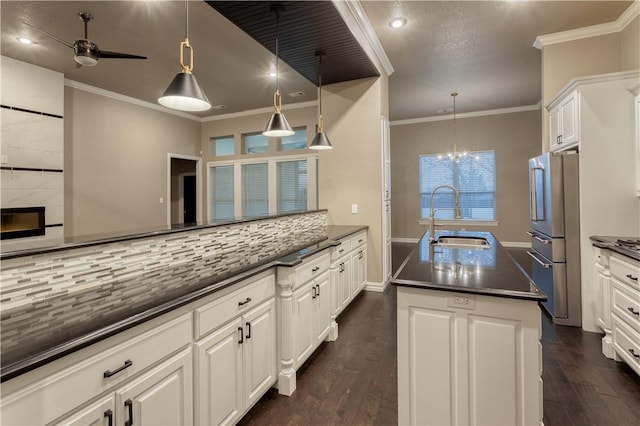 kitchen featuring dark wood-type flooring, a sink, stainless steel refrigerator, tasteful backsplash, and crown molding