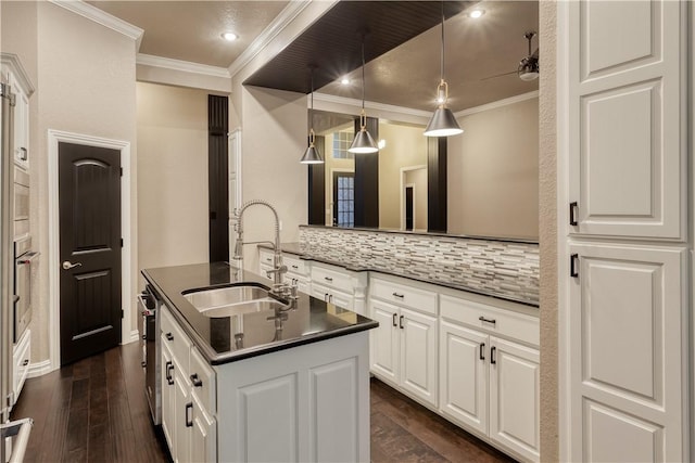 kitchen featuring crown molding, dark countertops, backsplash, a sink, and oven