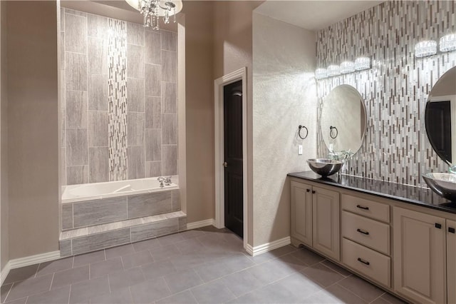 full bathroom with tasteful backsplash, tiled tub, a sink, and tile patterned flooring