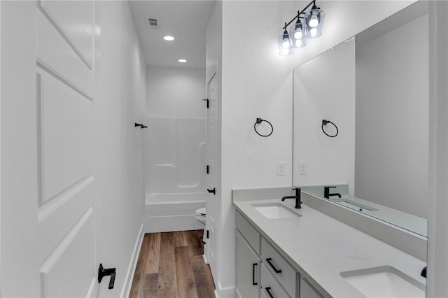 bathroom featuring vanity, hardwood / wood-style flooring, and toilet