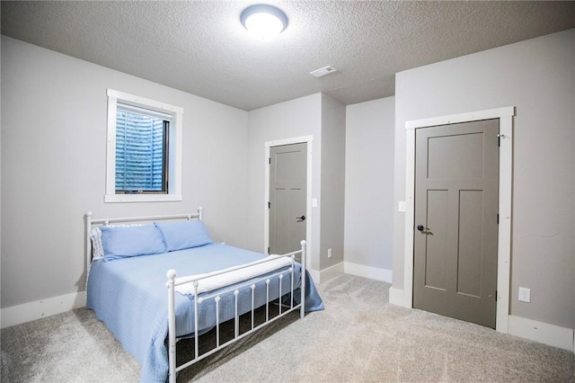 bedroom with carpet and a textured ceiling