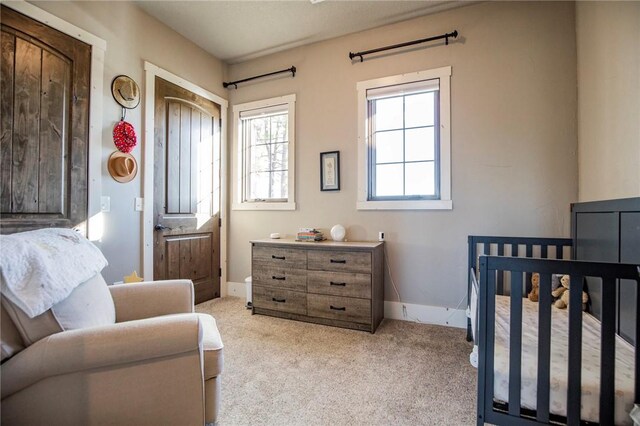 carpeted bedroom with a nursery area