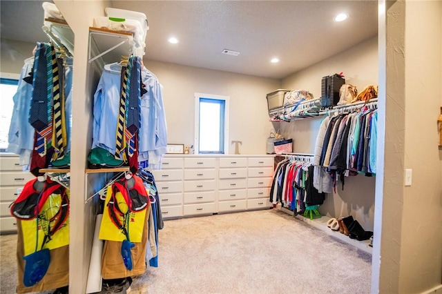 walk in closet featuring light colored carpet