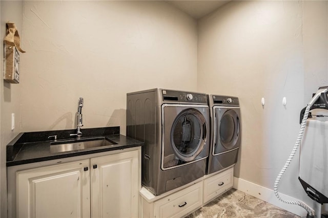 washroom with cabinets, sink, and washing machine and dryer