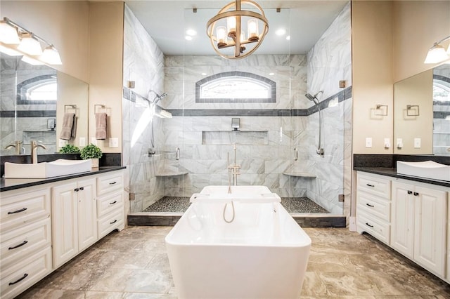 bathroom with a notable chandelier, vanity, plus walk in shower, and a wealth of natural light