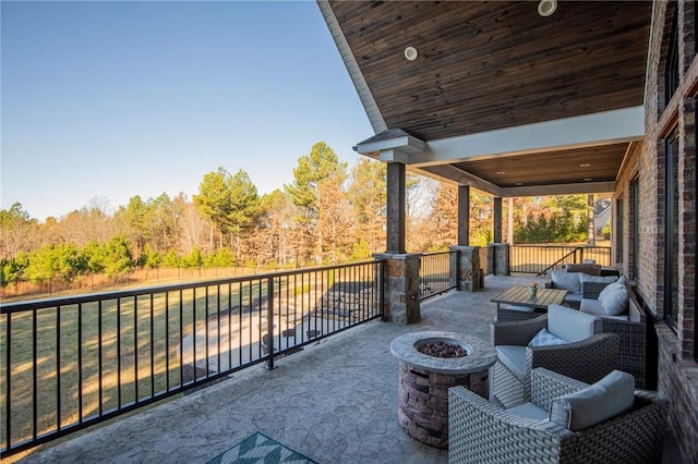 view of patio with an outdoor living space with a fire pit