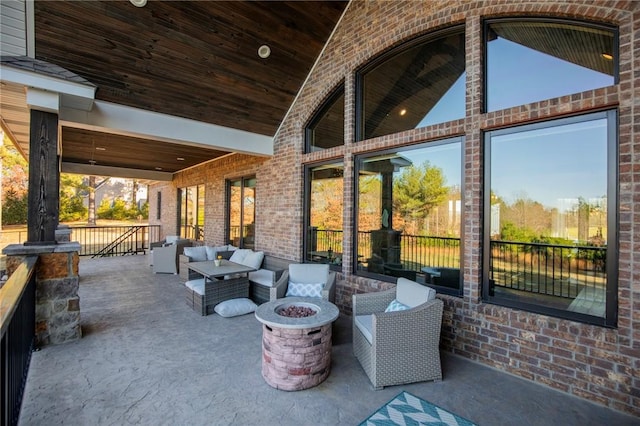 view of patio with an outdoor living space with a fire pit