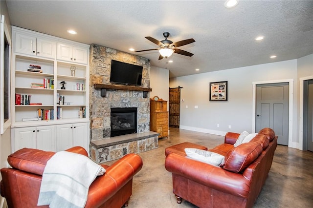 living room with a fireplace, concrete floors, a textured ceiling, and built in shelves