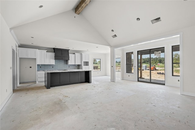 unfurnished living room featuring beam ceiling and high vaulted ceiling