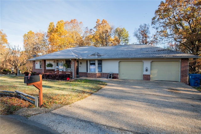 single story home with a front yard, a garage, and covered porch