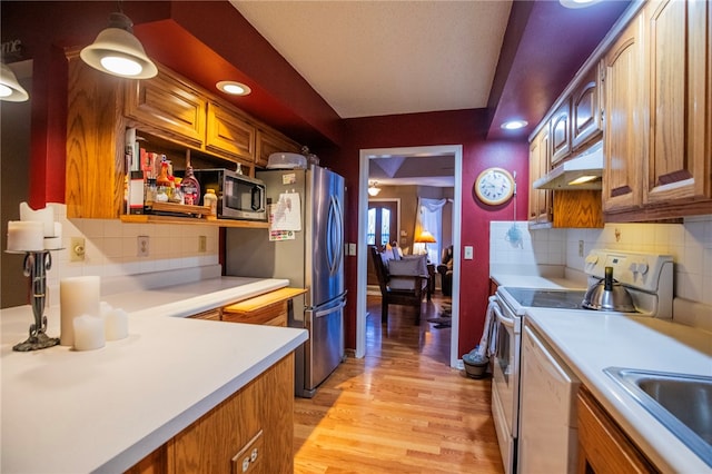 kitchen with decorative backsplash, light hardwood / wood-style floors, and stainless steel appliances