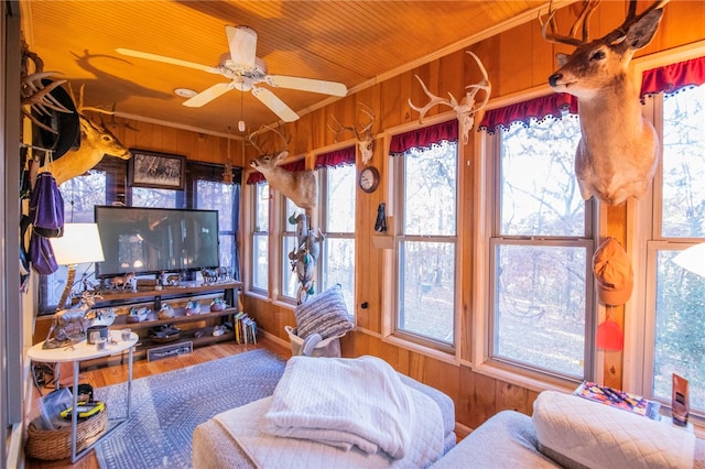 living room featuring plenty of natural light, wood-type flooring, and wooden walls