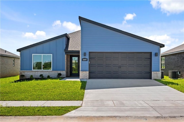 6309 NW Harley St, Bentonville, AR 72713 - mid-century home featuring brick siding, concrete driveway, a front yard, board and batten siding, and a garage