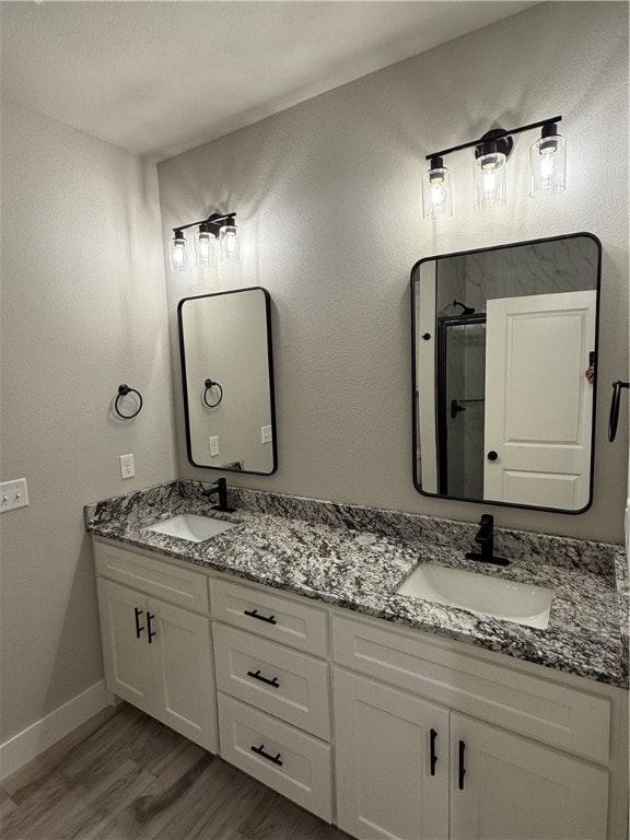 bathroom featuring hardwood / wood-style floors, vanity, and walk in shower