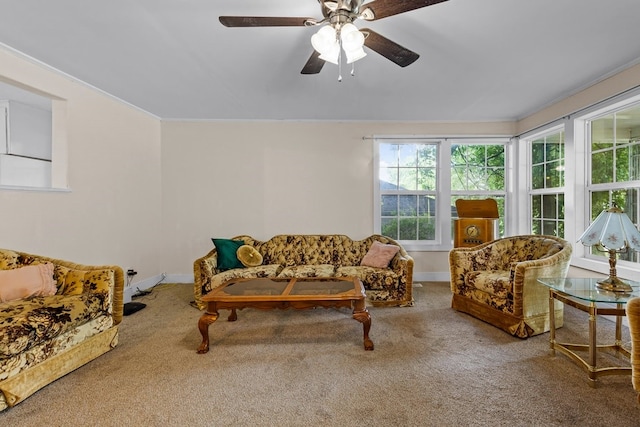 carpeted living room with ceiling fan and ornamental molding