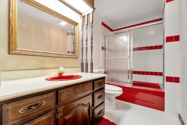 full bathroom with tile patterned flooring, vanity, toilet, and combined bath / shower with glass door