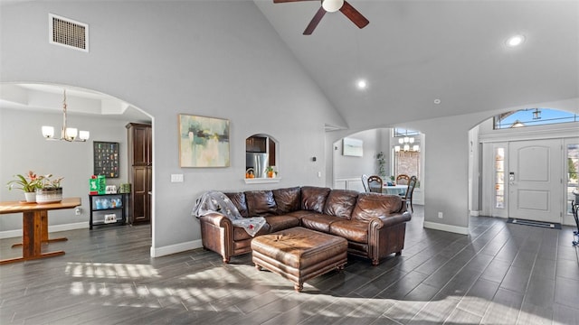 living room featuring ceiling fan with notable chandelier, dark wood-type flooring, and high vaulted ceiling