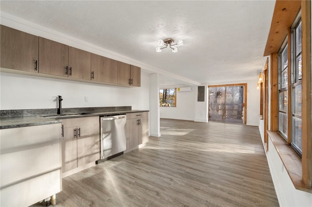 kitchen featuring sink, a wall mounted air conditioner, wood-type flooring, a textured ceiling, and stainless steel dishwasher