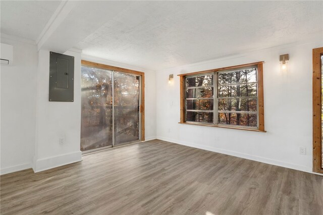 10305 Jims Trl, Rogers, AR 72756 - spare room featuring electric panel, wood finished floors, baseboards, and a textured ceiling