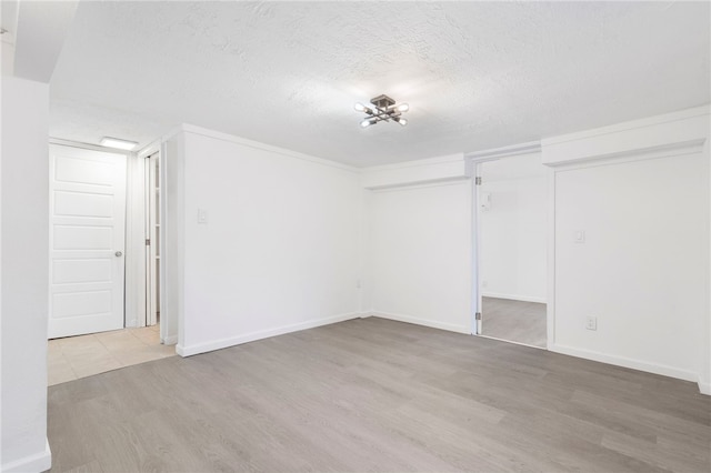 10305 Jims Trl, Rogers, AR 72756 - unfurnished bedroom featuring a textured ceiling, wood finished floors, and baseboards