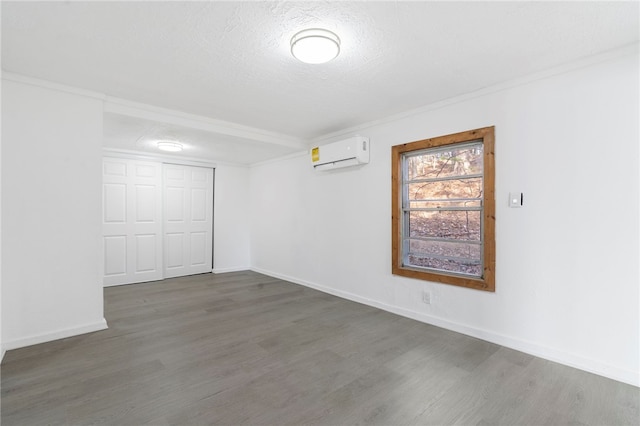 10305 Jims Trl, Rogers, AR 72756 - spare room featuring an AC wall unit, wood finished floors, baseboards, crown molding, and a textured ceiling