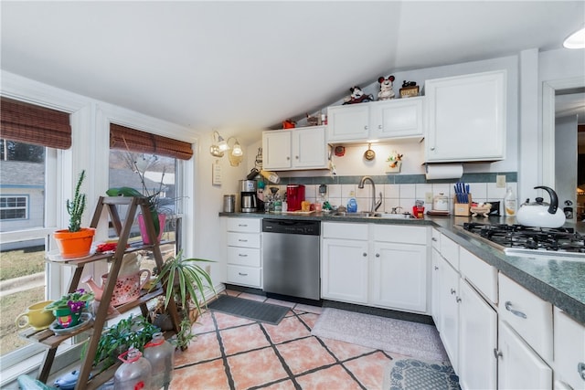 kitchen with white cabinetry, sink, stainless steel appliances, lofted ceiling, and decorative backsplash