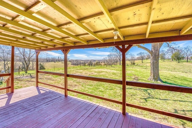 deck with a rural view and a lawn