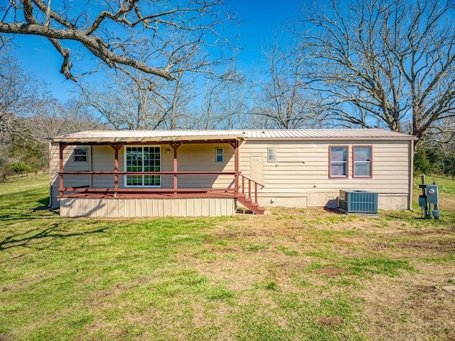 back of property with a lawn and central air condition unit