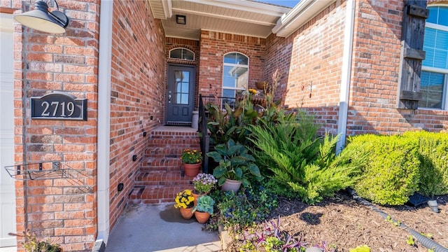 view of exterior entry featuring brick siding