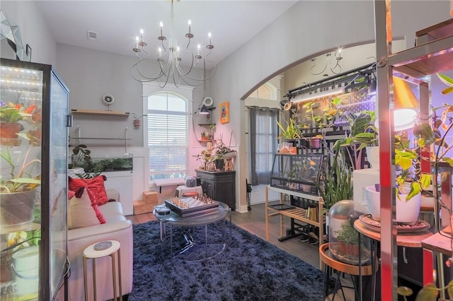 interior space with visible vents, a chandelier, vaulted ceiling, wood finished floors, and arched walkways