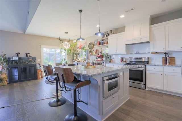 kitchen featuring a sink, tasteful backsplash, wood finished floors, appliances with stainless steel finishes, and white cabinets