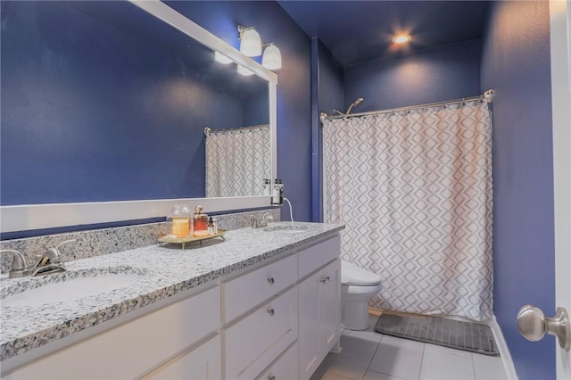 full bathroom featuring tile patterned floors, toilet, double vanity, and a sink