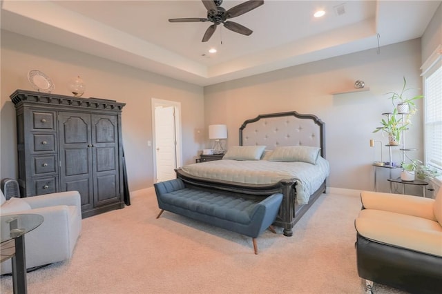 bedroom featuring visible vents, a tray ceiling, recessed lighting, light colored carpet, and ceiling fan