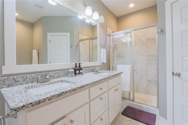 bathroom with a sink, visible vents, a stall shower, and double vanity