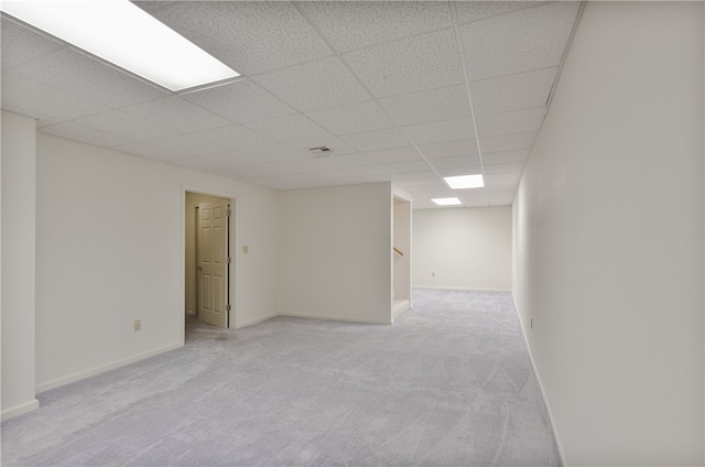 carpeted spare room featuring a drop ceiling