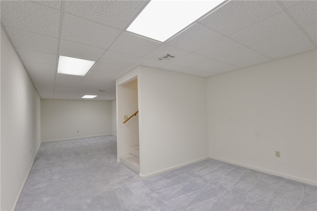 carpeted empty room with a drop ceiling