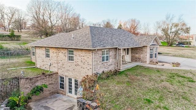 view of side of property featuring french doors, a patio, and a lawn